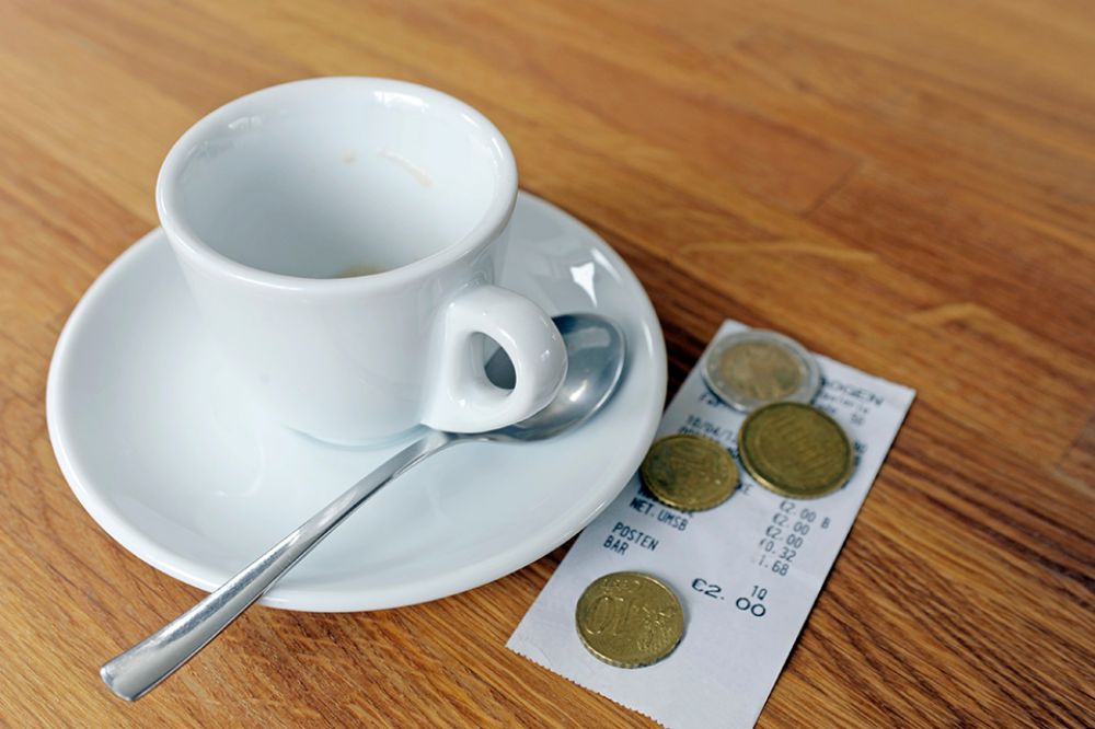 Foto: Kaffeetasse mit Rechnung und Münzen